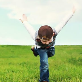 exuberant child outdoors in yoga pose